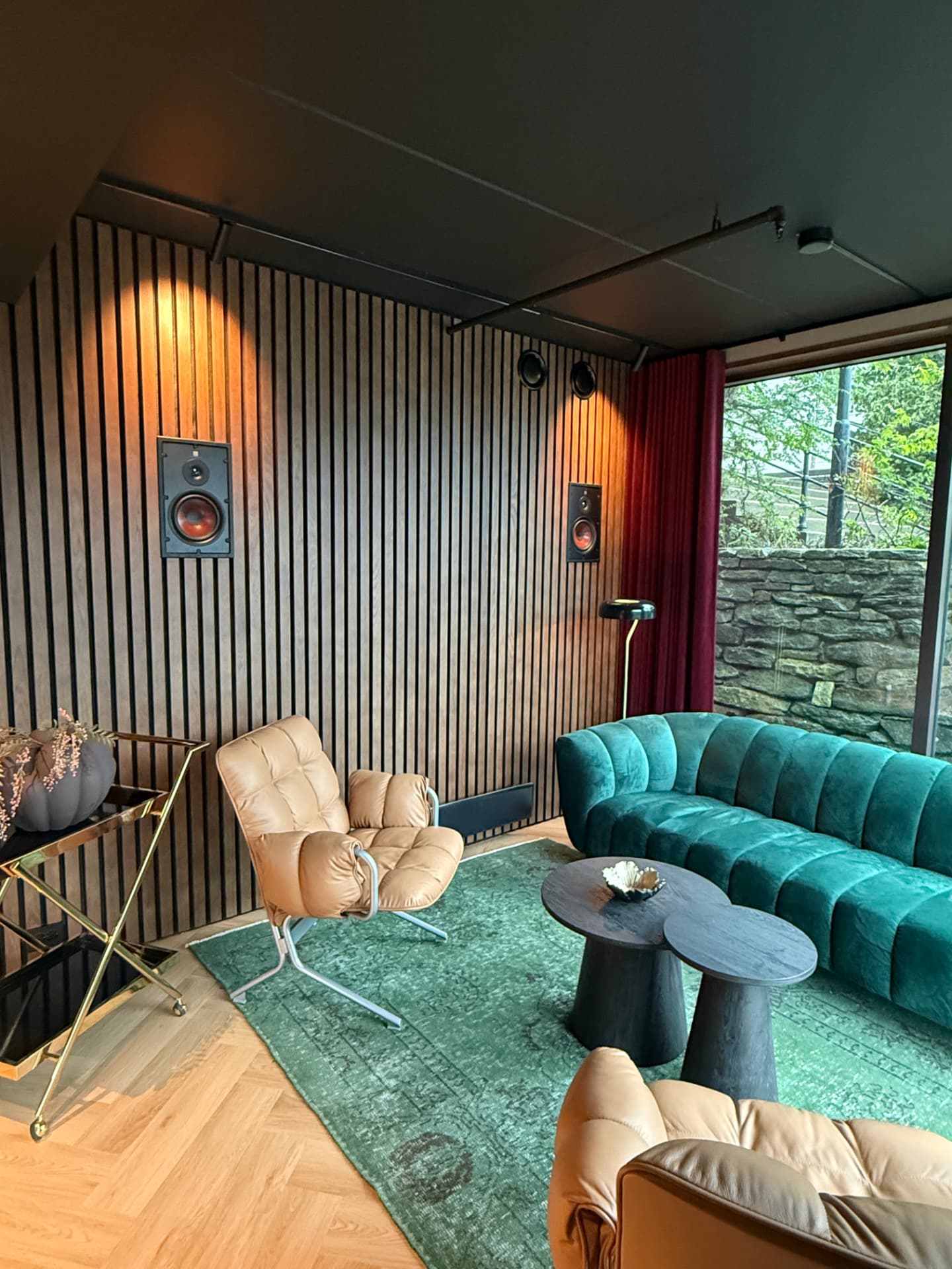 Loungeområdet med grønn velur og trepanel